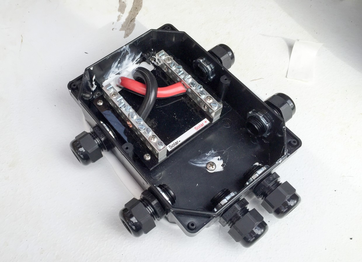 Combiner box mounted on roof and wires attached.